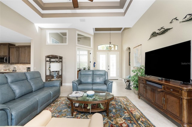 tiled living room featuring ornamental molding and a high ceiling