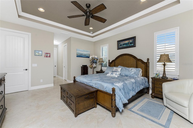 bedroom with ceiling fan, a tray ceiling, ornamental molding, and multiple windows