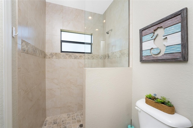 bathroom with toilet and a tile shower