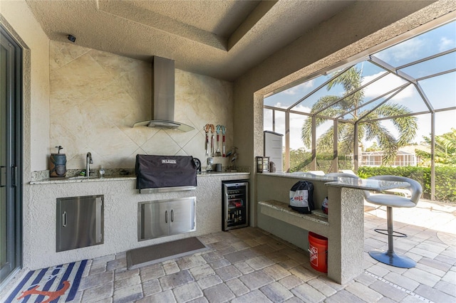 view of patio featuring area for grilling, exterior kitchen, sink, beverage cooler, and glass enclosure