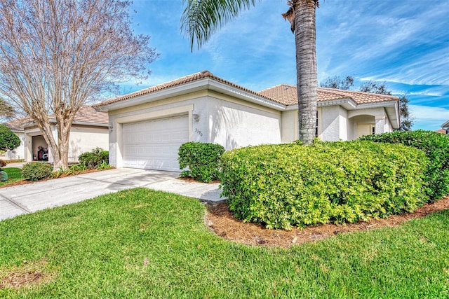 mediterranean / spanish-style home featuring a front yard and a garage