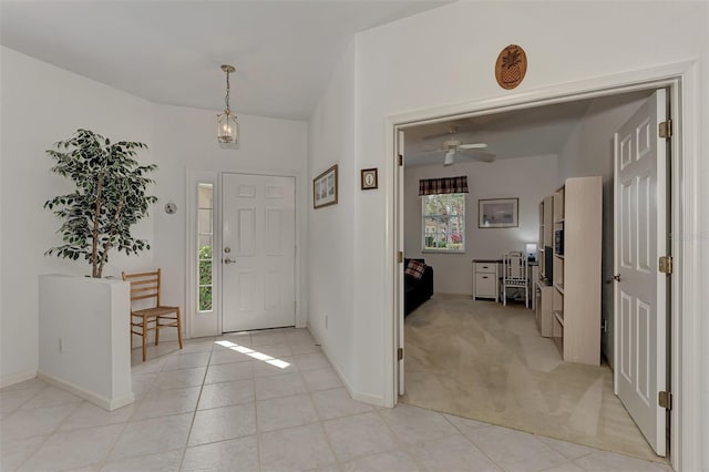 carpeted entryway with ceiling fan