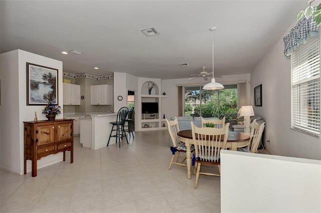 dining room featuring ceiling fan, built in shelves, light tile patterned floors, and plenty of natural light