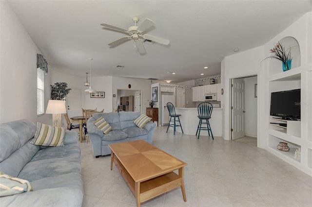 living room featuring ceiling fan, built in features, and light tile patterned floors