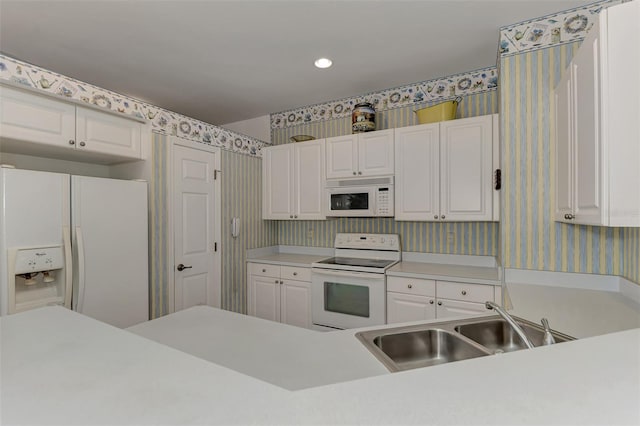 kitchen with sink, white cabinets, and white appliances