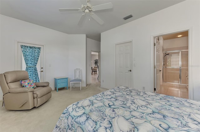 bedroom featuring ensuite bath, light carpet, and ceiling fan