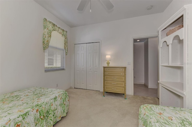 bedroom featuring a closet, light colored carpet, and ceiling fan