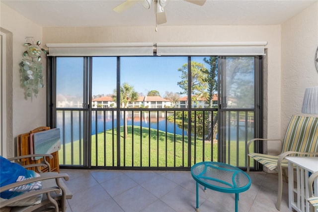 sunroom / solarium with a water view and ceiling fan