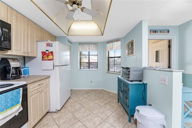 kitchen with light brown cabinetry, light tile patterned floors, white appliances, and ceiling fan