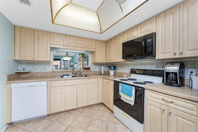 kitchen featuring sink, light brown cabinetry, and white appliances