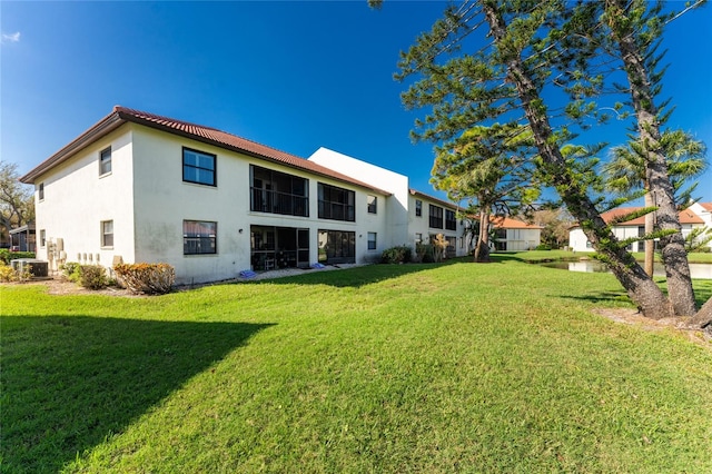 rear view of property with a yard and cooling unit