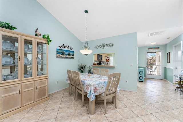 dining area with lofted ceiling and light tile patterned floors