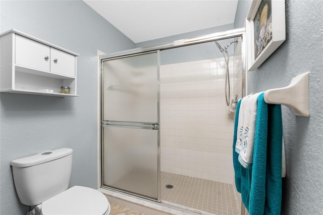 bathroom with toilet and a shower with door