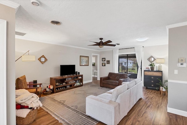 living room featuring ornamental molding, ceiling fan, a textured ceiling, and dark hardwood / wood-style flooring