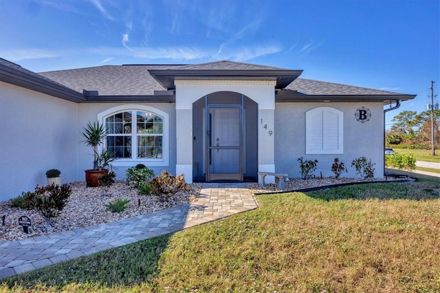 doorway to property with a lawn