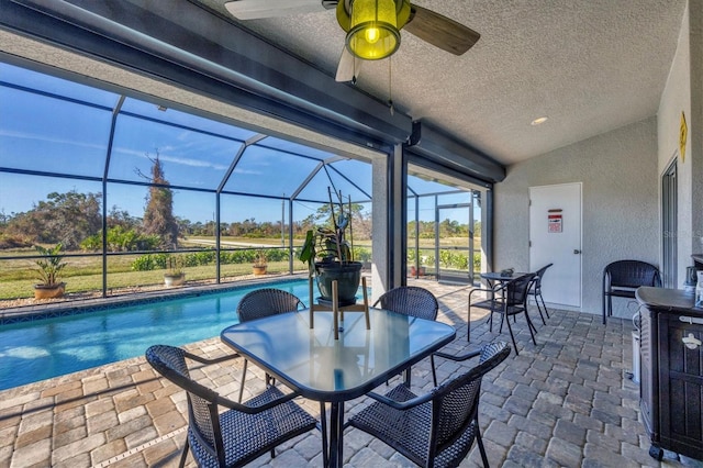 view of patio featuring ceiling fan and a lanai