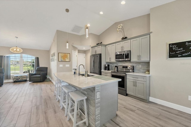 kitchen featuring gray cabinets, sink, appliances with stainless steel finishes, and decorative light fixtures