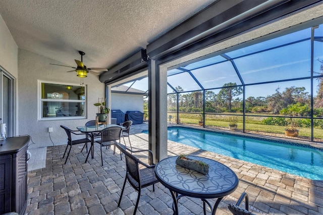 view of swimming pool with a patio, a lanai, and ceiling fan