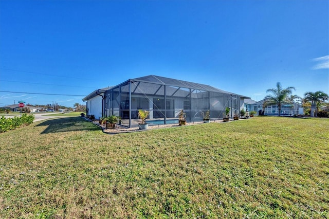 back of property with a yard and glass enclosure