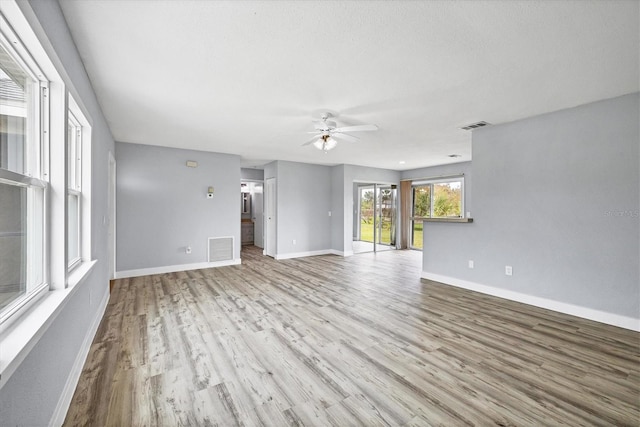 unfurnished living room featuring ceiling fan and light wood-type flooring