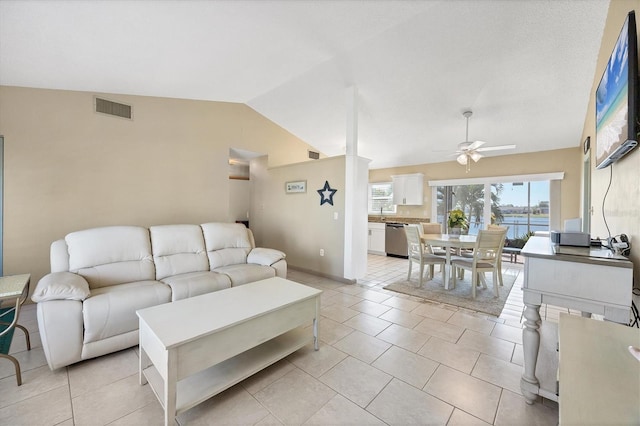 living room with ceiling fan, light tile patterned flooring, and vaulted ceiling