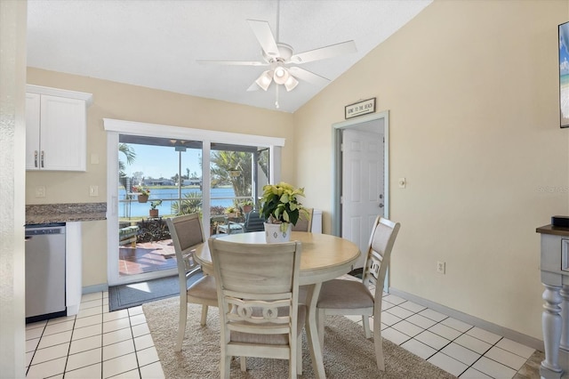 tiled dining area with a water view, ceiling fan, and lofted ceiling