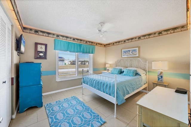 bedroom featuring light tile patterned floors, a textured ceiling, a closet, and ceiling fan