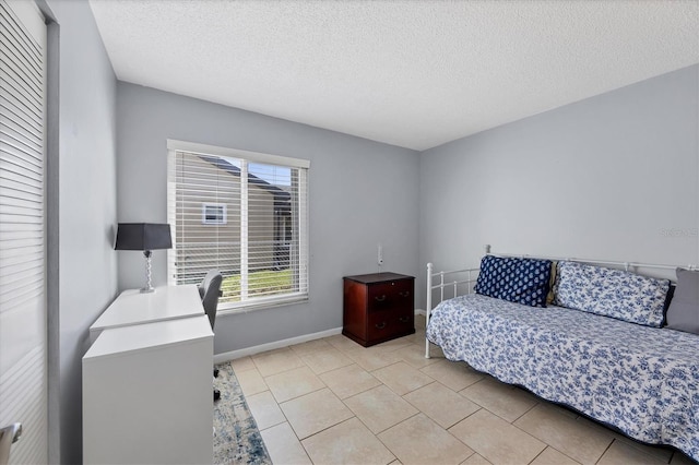 bedroom featuring light tile patterned flooring and a textured ceiling