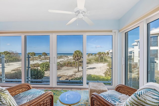 sunroom / solarium with a water view and ceiling fan