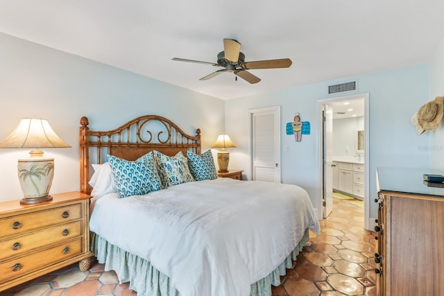 bedroom with connected bathroom, a closet, light tile patterned flooring, and ceiling fan