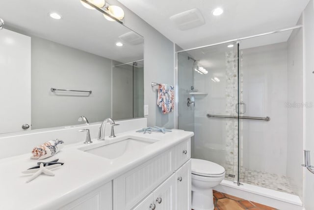 bathroom featuring a shower with door, vanity, and toilet