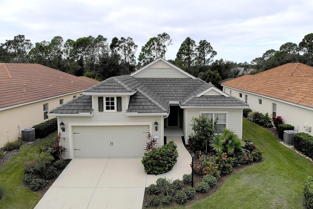 view of front of house with central air condition unit, a front yard, and a garage