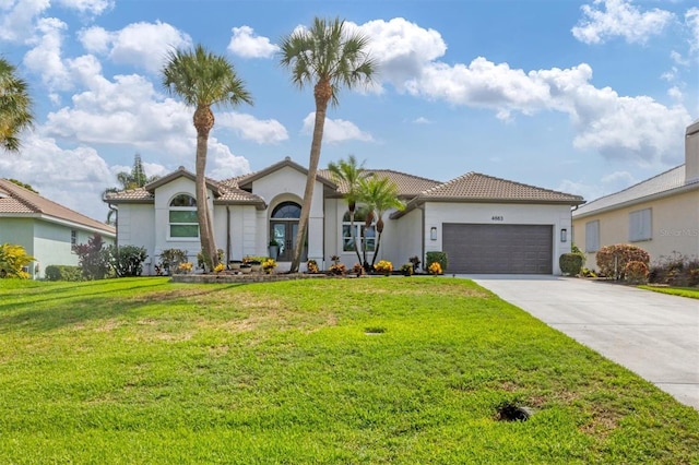 mediterranean / spanish-style house featuring a garage and a front lawn