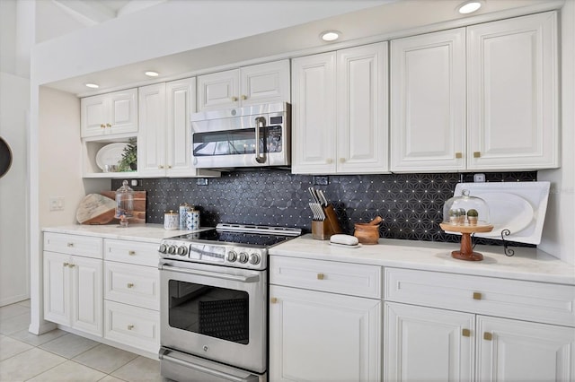 kitchen with backsplash, stainless steel appliances, white cabinets, and light tile patterned flooring