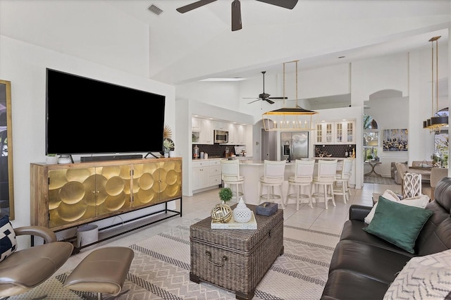 tiled living room with high vaulted ceiling and ceiling fan