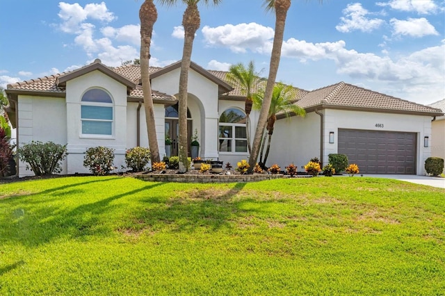 mediterranean / spanish home with a garage and a front yard