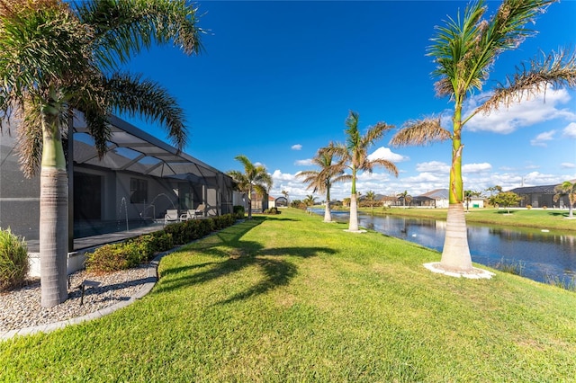 view of yard with a water view and a lanai