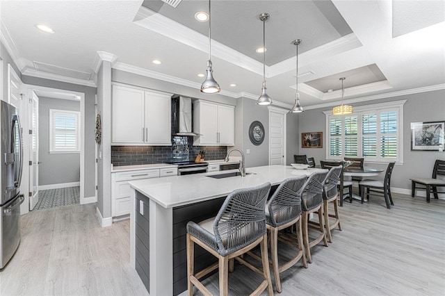 kitchen with white cabinets, a healthy amount of sunlight, sink, and a center island with sink