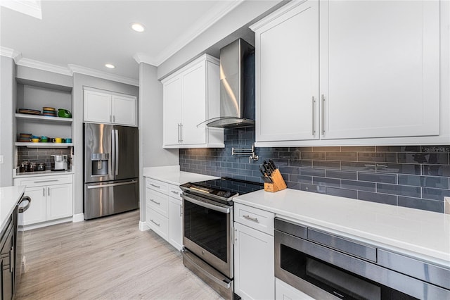 kitchen with white cabinets, tasteful backsplash, light hardwood / wood-style flooring, wall chimney exhaust hood, and stainless steel appliances