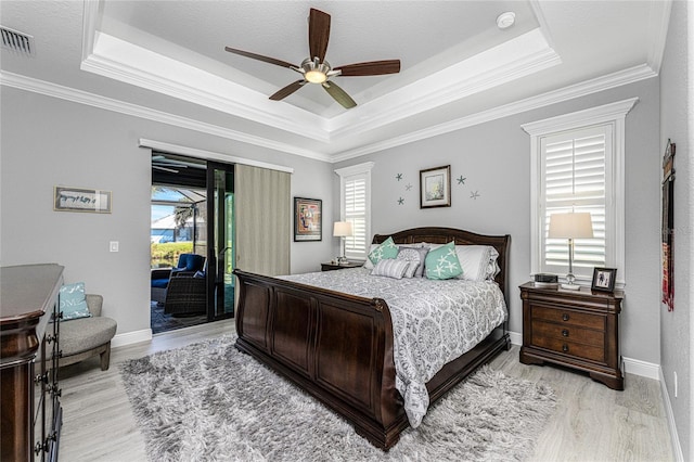 bedroom with ceiling fan, ornamental molding, multiple windows, and access to exterior