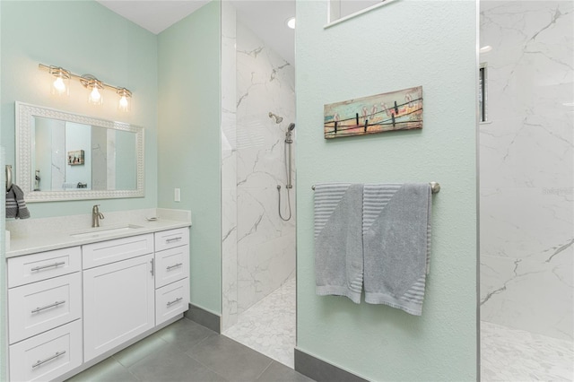 bathroom with vanity, a tile shower, and tile patterned floors