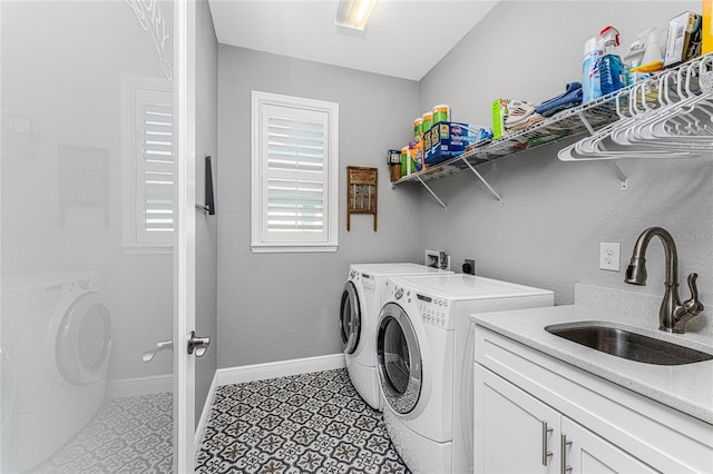 laundry area featuring sink, washer and clothes dryer, cabinets, and light tile patterned floors