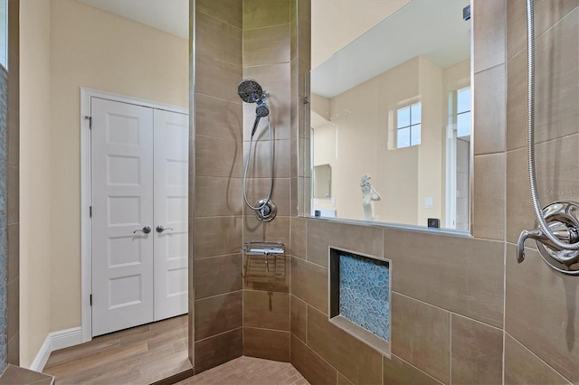 bathroom featuring wood-type flooring and tiled shower