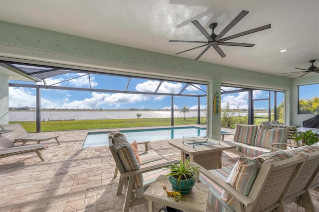 sunroom / solarium featuring a water view and ceiling fan