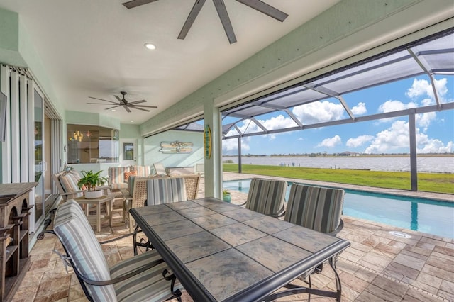 sunroom / solarium featuring a water view and ceiling fan