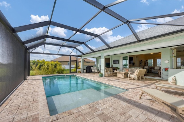 view of swimming pool with outdoor lounge area, a patio, and a lanai