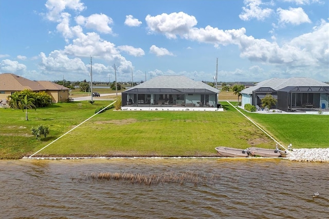 back of property featuring a yard, a water view, and a lanai