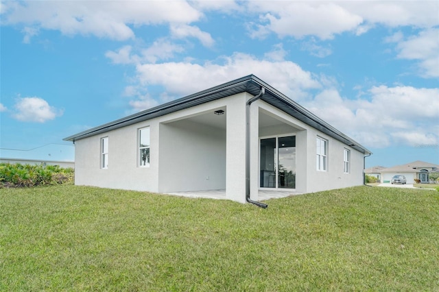 back of property featuring a lawn and a patio area