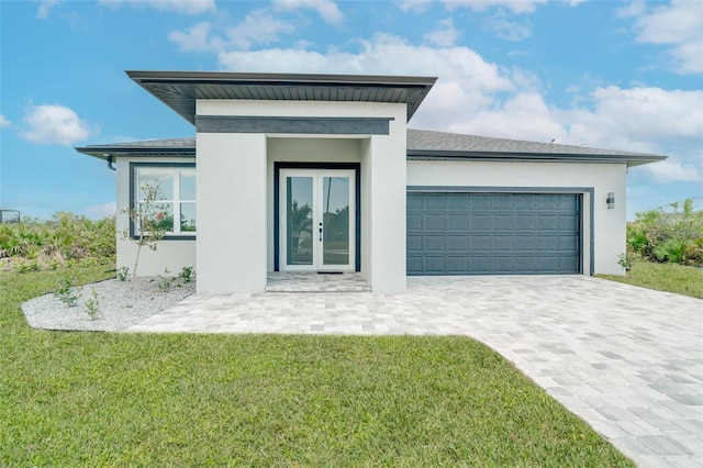 exterior space with a garage, a front lawn, and french doors