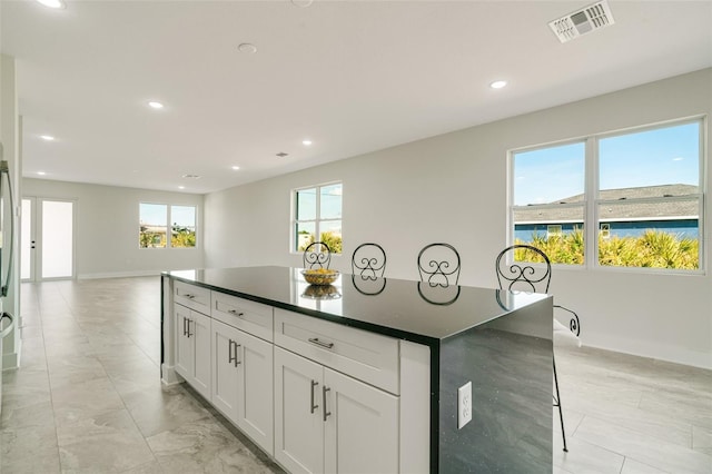 kitchen with a center island, a breakfast bar area, and white cabinets